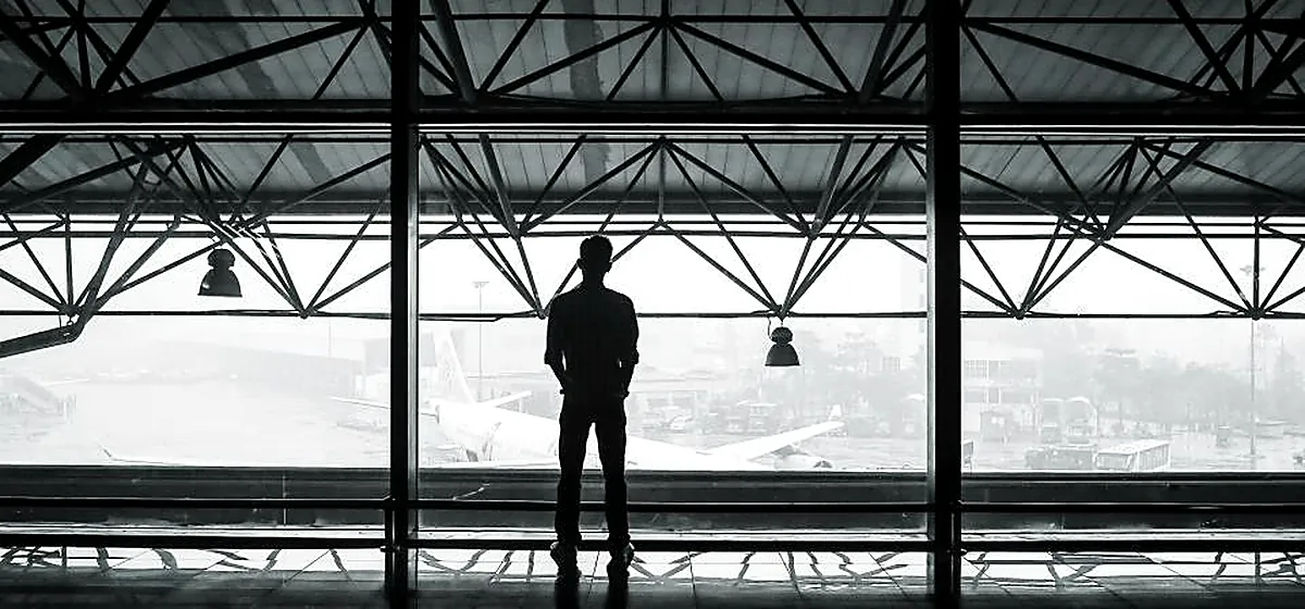A traveller standing in a station concourse
