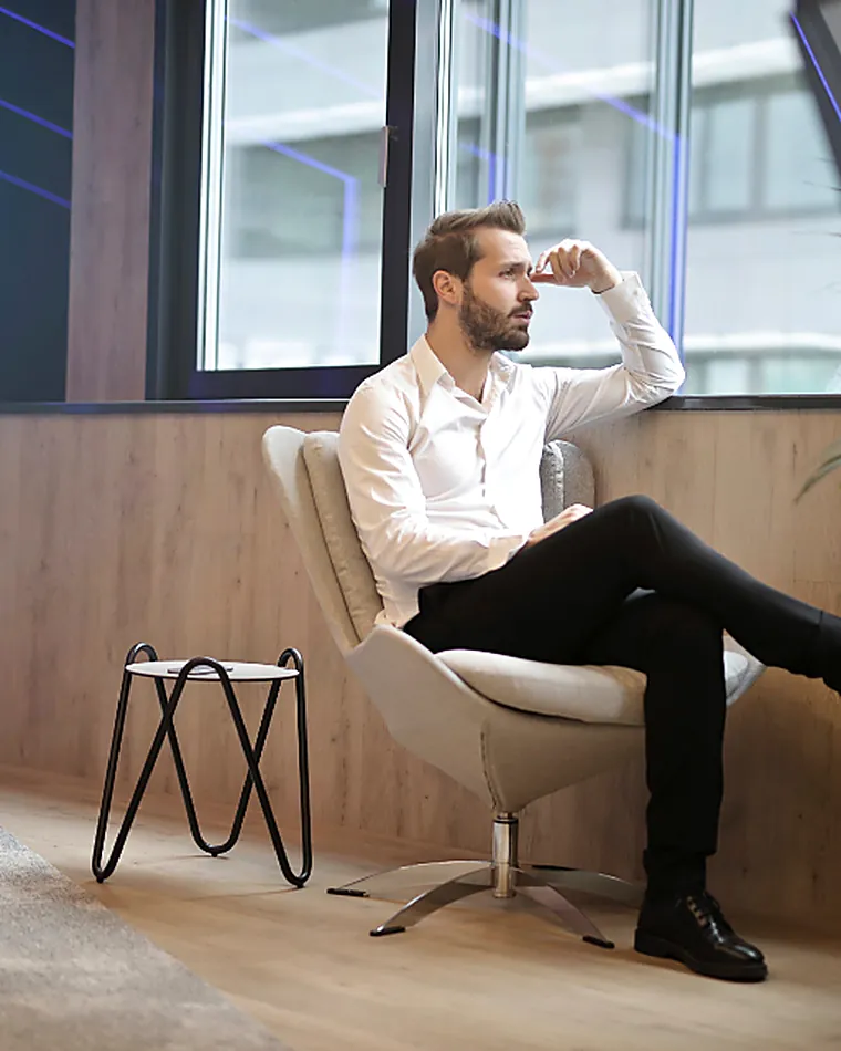 A person sitting near a large window in a quiet room