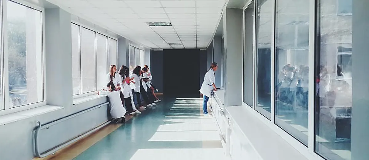 A long hospital corridor with people at the far end