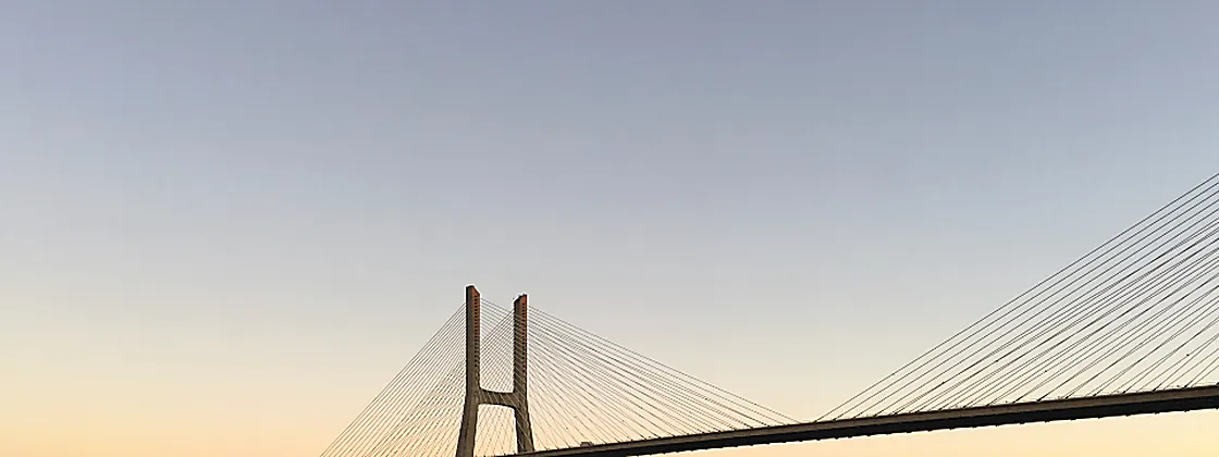 A long causeway bridge reaching across water at first light