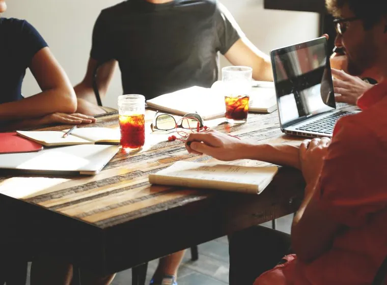 Colleagues working through a plan together at a shared table