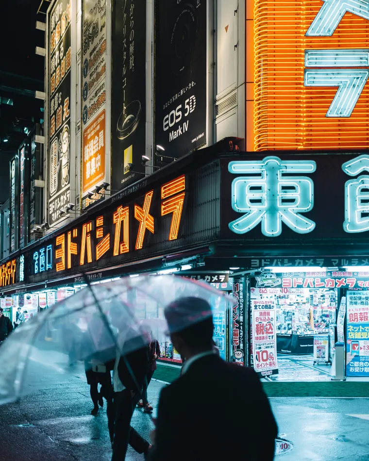 A city street at night lit by signs