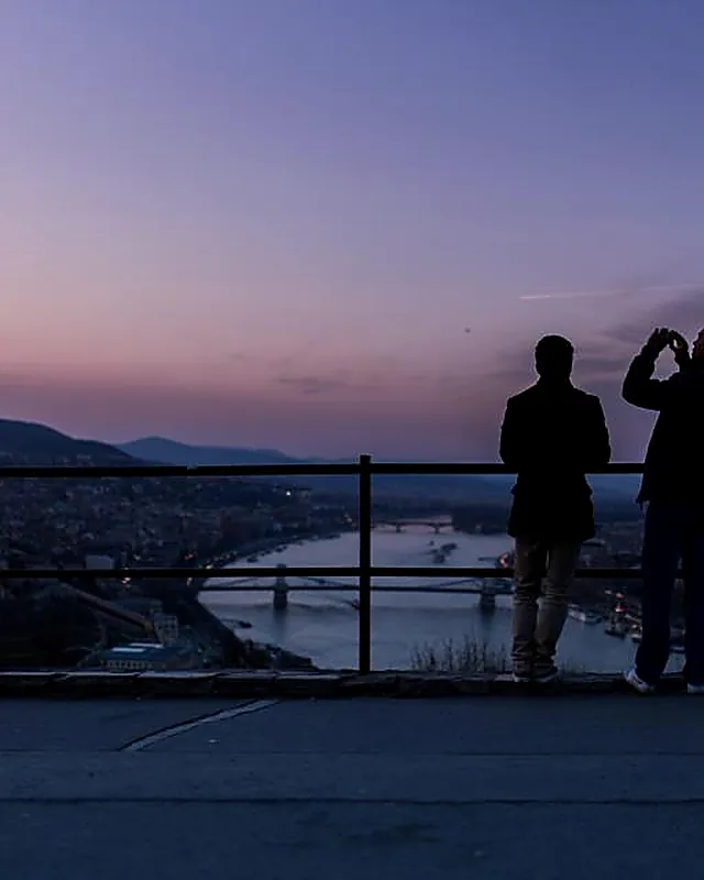 Two people looking out across a river crossing at dusk