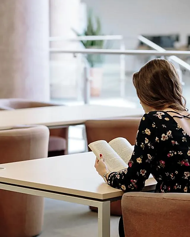 A woman studying at a table in a library