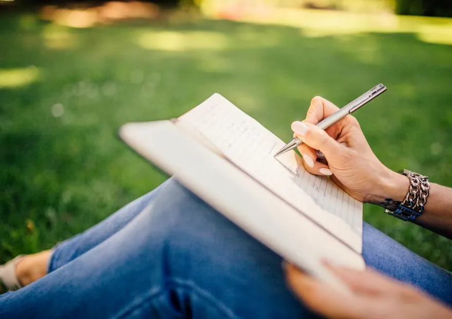 Someone writing notes by hand in a notebook