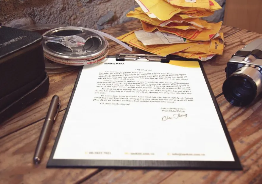 A clipboard of documents and a pen on a desk