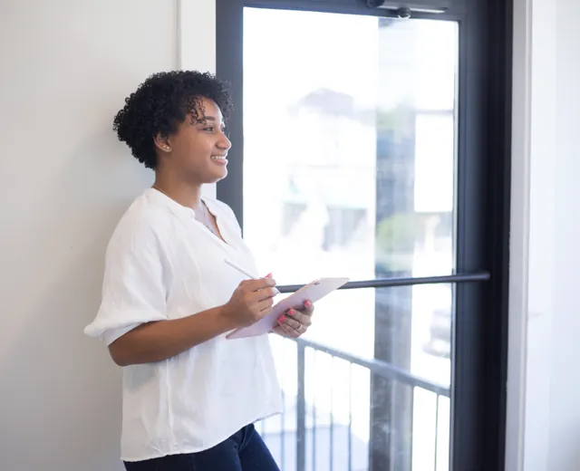 A professional presenting to colleagues by a window
