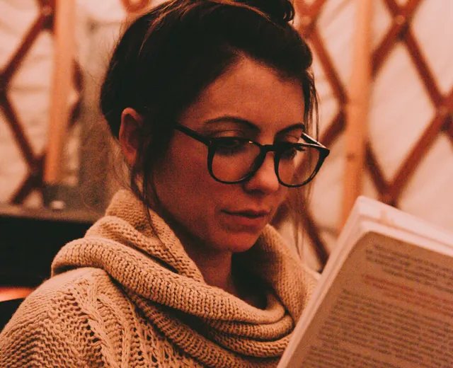 A person reviewing documents carefully in warm light