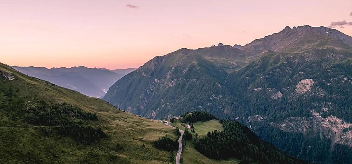 A path leading through open hills at first light